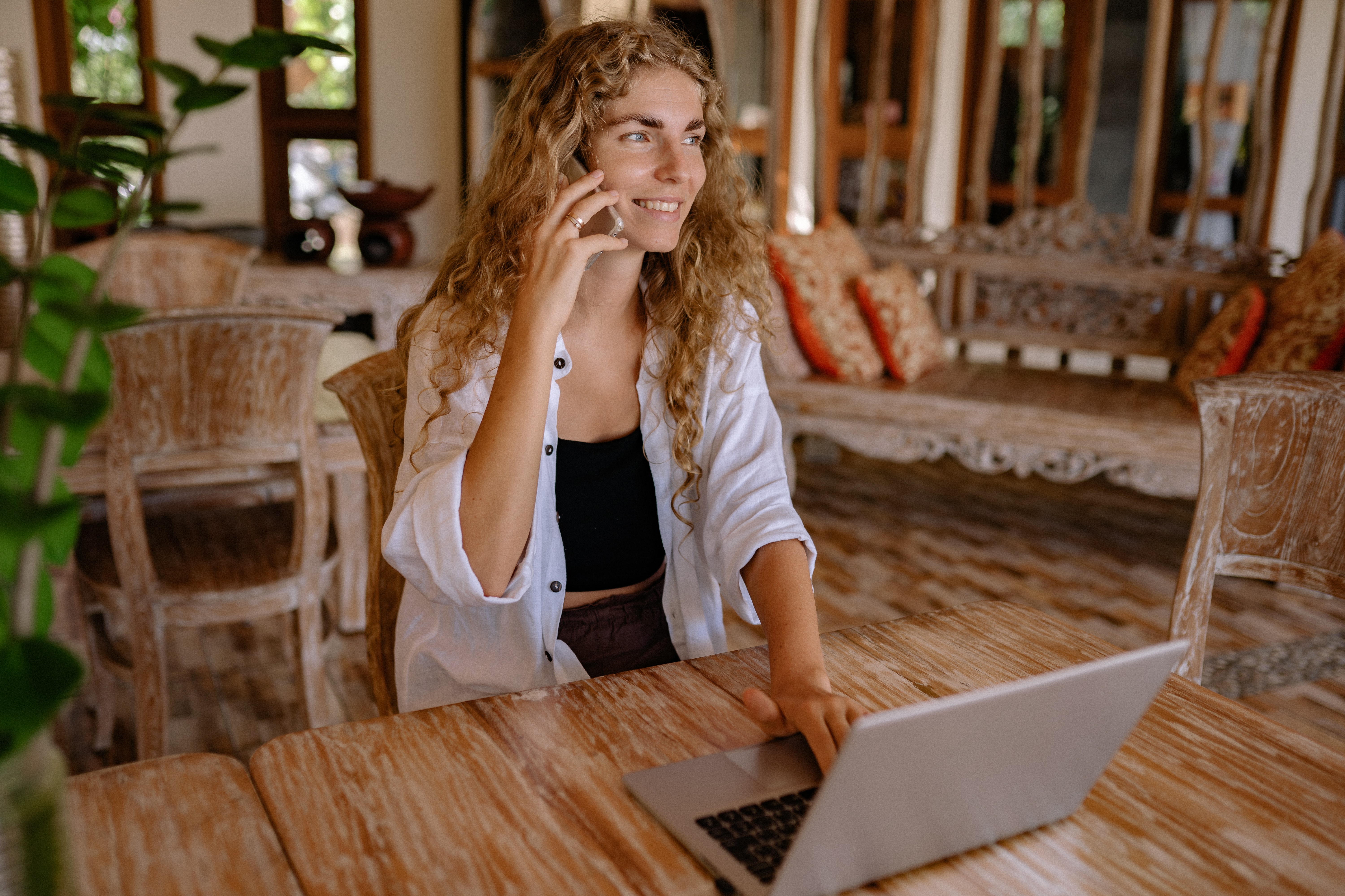 Image of woman on the phone and using a laptop